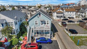 A residential area with houses, a driveway, and parked cars. - Shannon A - downstairs (Ocean City)