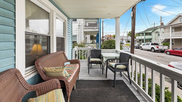 A covered porch with wicker furniture, a table, and chairs. - Shannon A - downstairs (Ocean City)