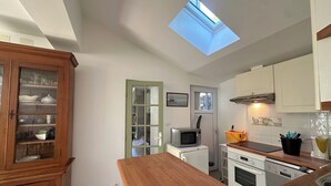 A compact kitchen with a skylight, wooden cabinets, a microwave, and a dishwasher. - La Rochelle -House with billiard table (La Rochelle)