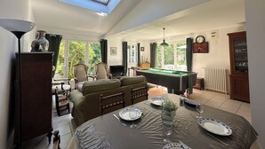 A spacious living room with a pool table, a sofa, and a dining table set for two. - La Rochelle -House with billiard table (La Rochelle)