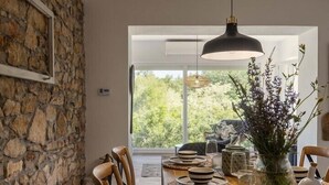 Zona pranzo con tavolo in legno, sedie e lampadario.