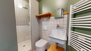 A bathroom with a shower, toilet, sink, and a towel rack. - Altido Pleasant 1-bed Flat w Shared Courtyard (Paris)