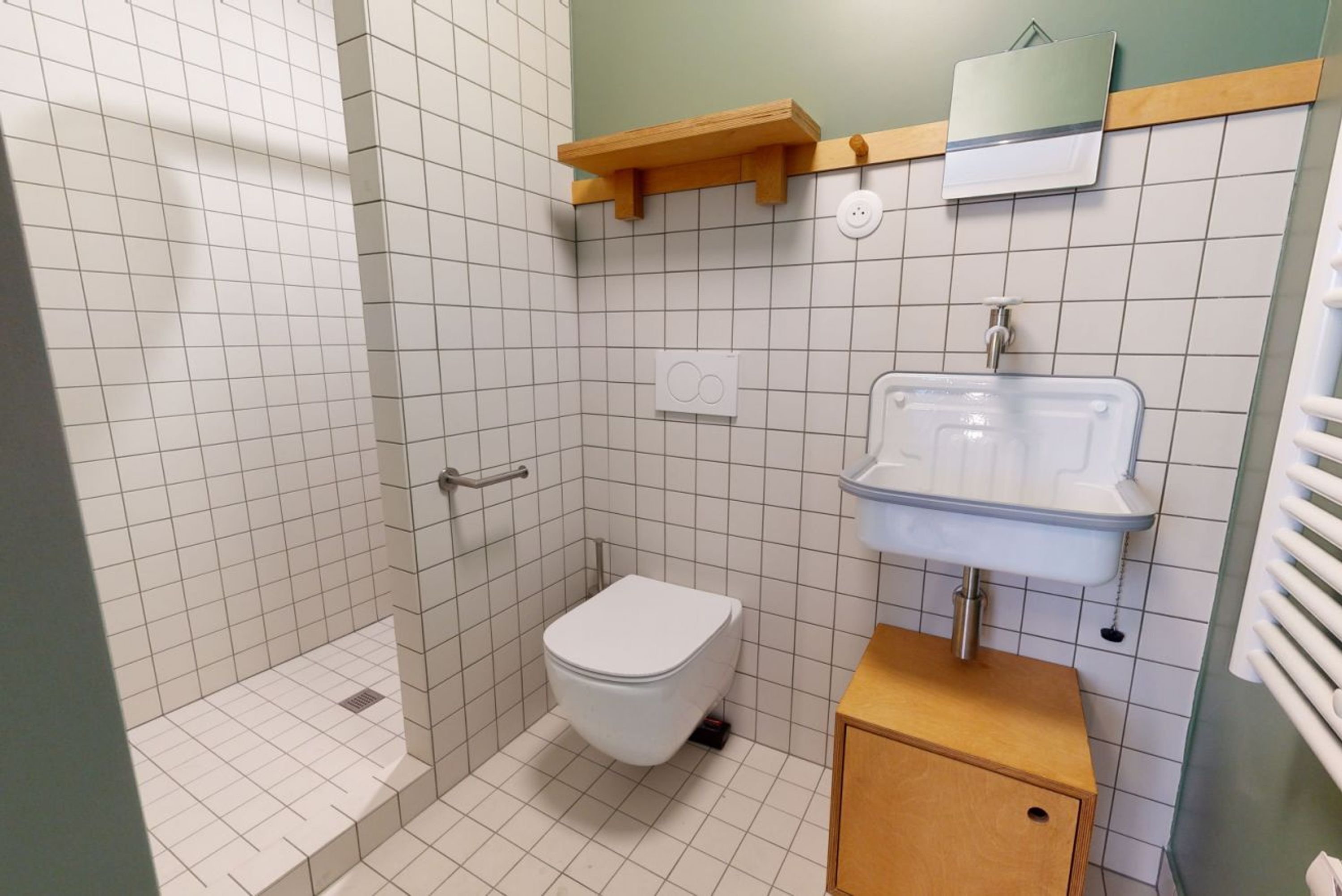 A bathroom with a toilet, a sink, and a shower area.