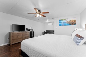 A bedroom with a large bed, a ceiling fan, a TV, a dresser, and a painting on the wall. - Sc12- Silver Cove 12 1 Bedroom Condo (Branson)