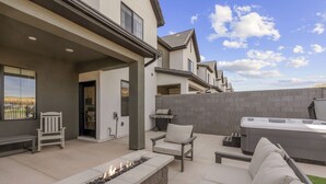 A modern outdoor patio with a fire pit, seating, and a hot tub. - Sunseekers Escape 4 Bedroom Townhouse (Washington)