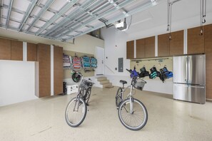 A spacious kitchen with a stainless steel refrigerator, two bicycles, and a wall-mounted bike rack. - Walk to beach waterfront home w/ pool, spa & kayaks (Marco Island)