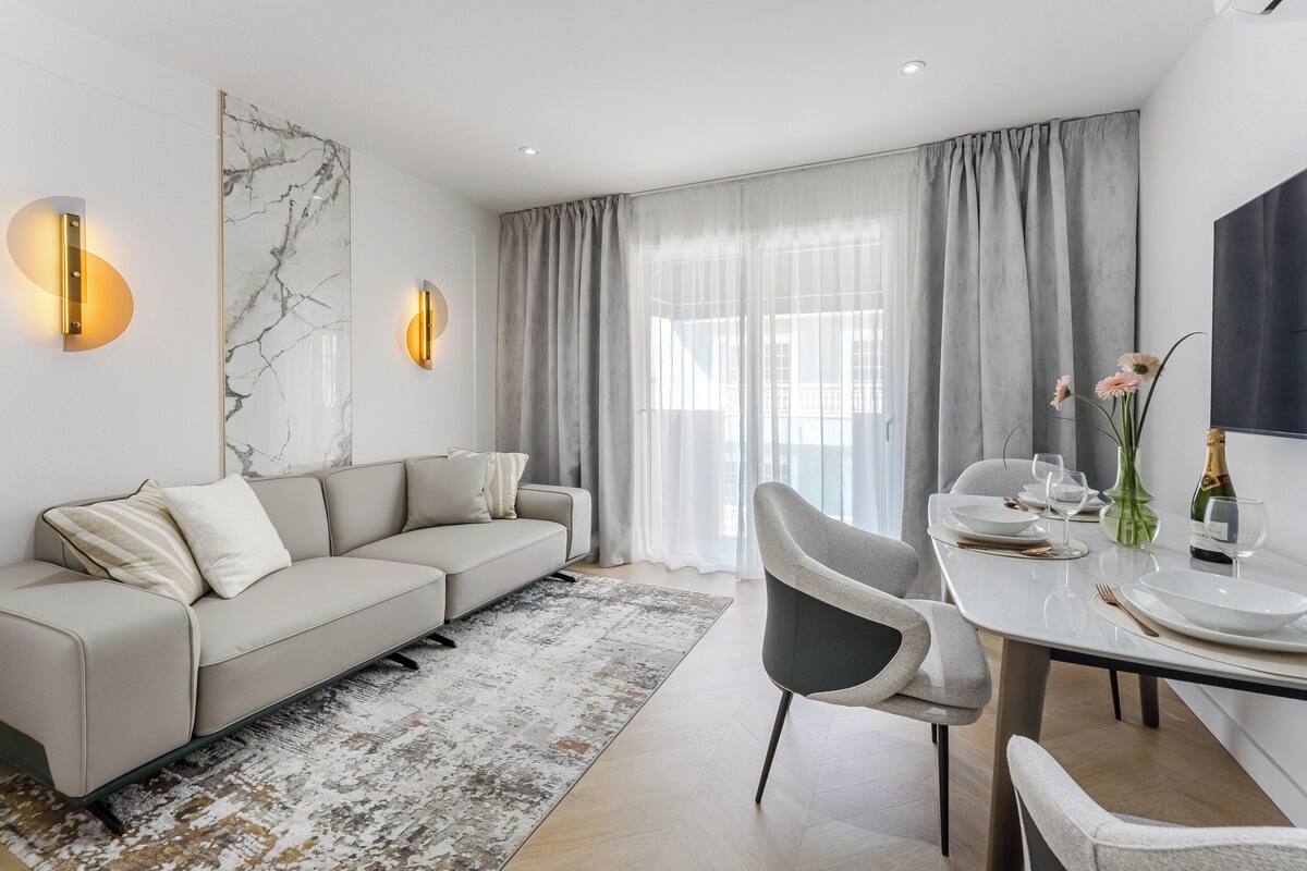 Ein modernes Wohnzimmer mit einer Couch, einem Esstisch und Stühlen.