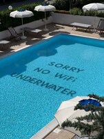 季节性开放的室外游泳池，池畔遮阳伞，日光浴躺椅