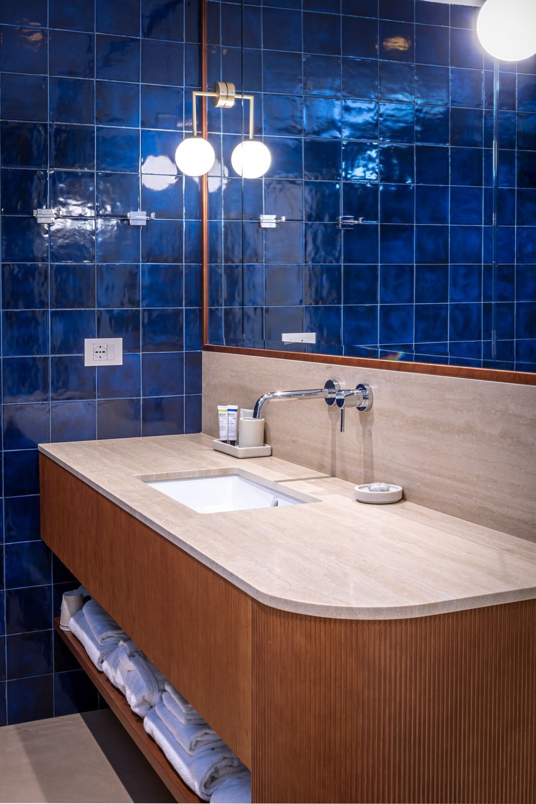 Un baño moderno con dos lavamanos, un mueble de tocador de madera y un espejo grande.