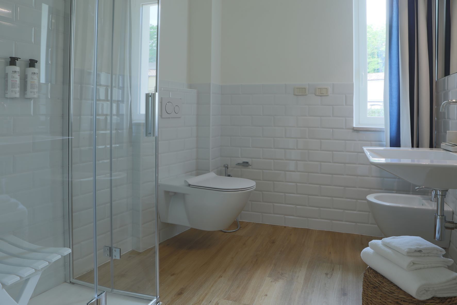 Un baño moderno con cabina de ducha de vidrio, inodoro y lavamanos.