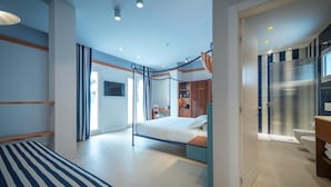 A modern bedroom with a bed, a desk, and a bathroom visible through an open door. - Hotel Murè (Numana)