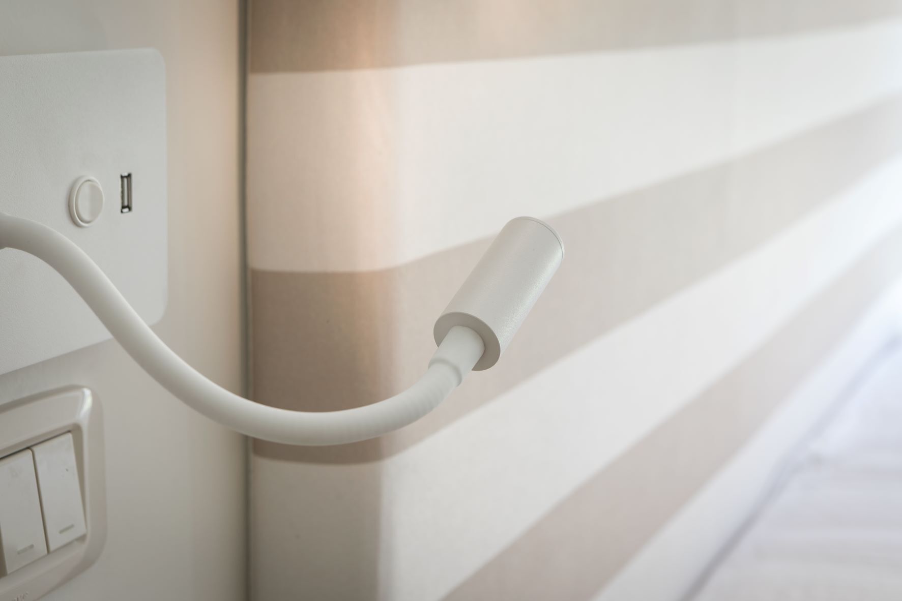 Eine wandmontierte Steckdose mit weißem Kabel.