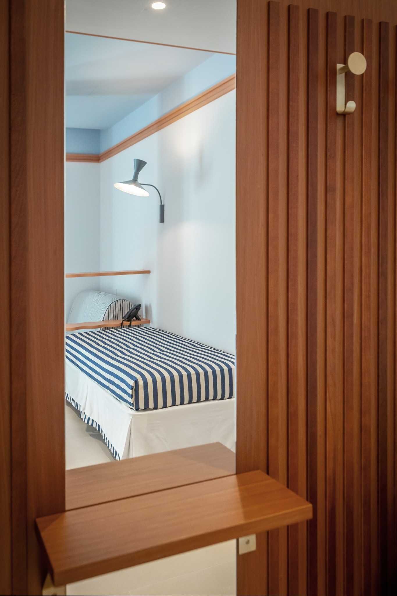 A bedroom with a bed, bedside table, and a lamp.