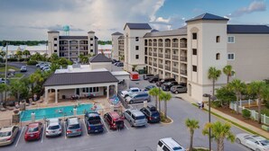 A hotel with multiple buildings, a swimming pool, and a parking area. - Beach, Swim, Chill, Repeat – Alerio E202 (Miramar Beach)
