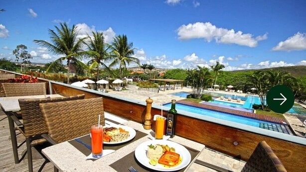 Ein Dachterrassen-Essbereich mit Blick auf einen Pool, inklusive Tische, Stühle und ein Buffet mit Speisen und Getränken.