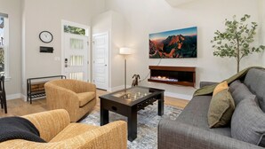 A living room with a foosball table, a sofa, and a fireplace. - Ram’s Roost | Rooftop Hot Tub, Patio & Family Fun (Fort Collins)