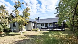 A two-story house with a covered porch and a fenced yard. - Beachfront holiday home with sea view in Sölvesborg | SE03021 (Sölvesborg)
