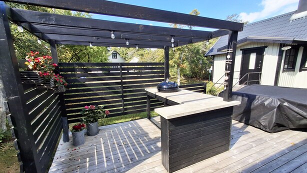 A wooden deck with a pergola, a barbecue grill, and a table. - Beachfront holiday home with sea view in Sölvesborg | SE03021 (Sölvesborg)