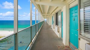 A corridor with a view of the beach and ocean. - Mermaid Oasis | Updated 4th-Floor Studio w/ Pool & Gulf Views (Panama City Beach)