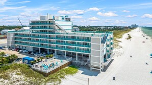 A multi-story hotel with a beach view, featuring a pool area and a parking lot. - Mermaid Oasis | Updated 4th-Floor Studio w/ Pool & Gulf Views (Panama City Beach)
