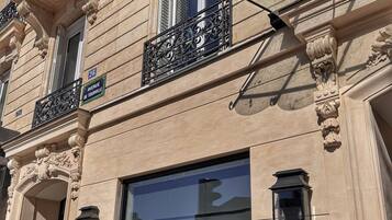 A building facade with a large window, a street sign reading 'Avenue de Tourville,' and a sign for 'Eiffel Yard Hotel.'