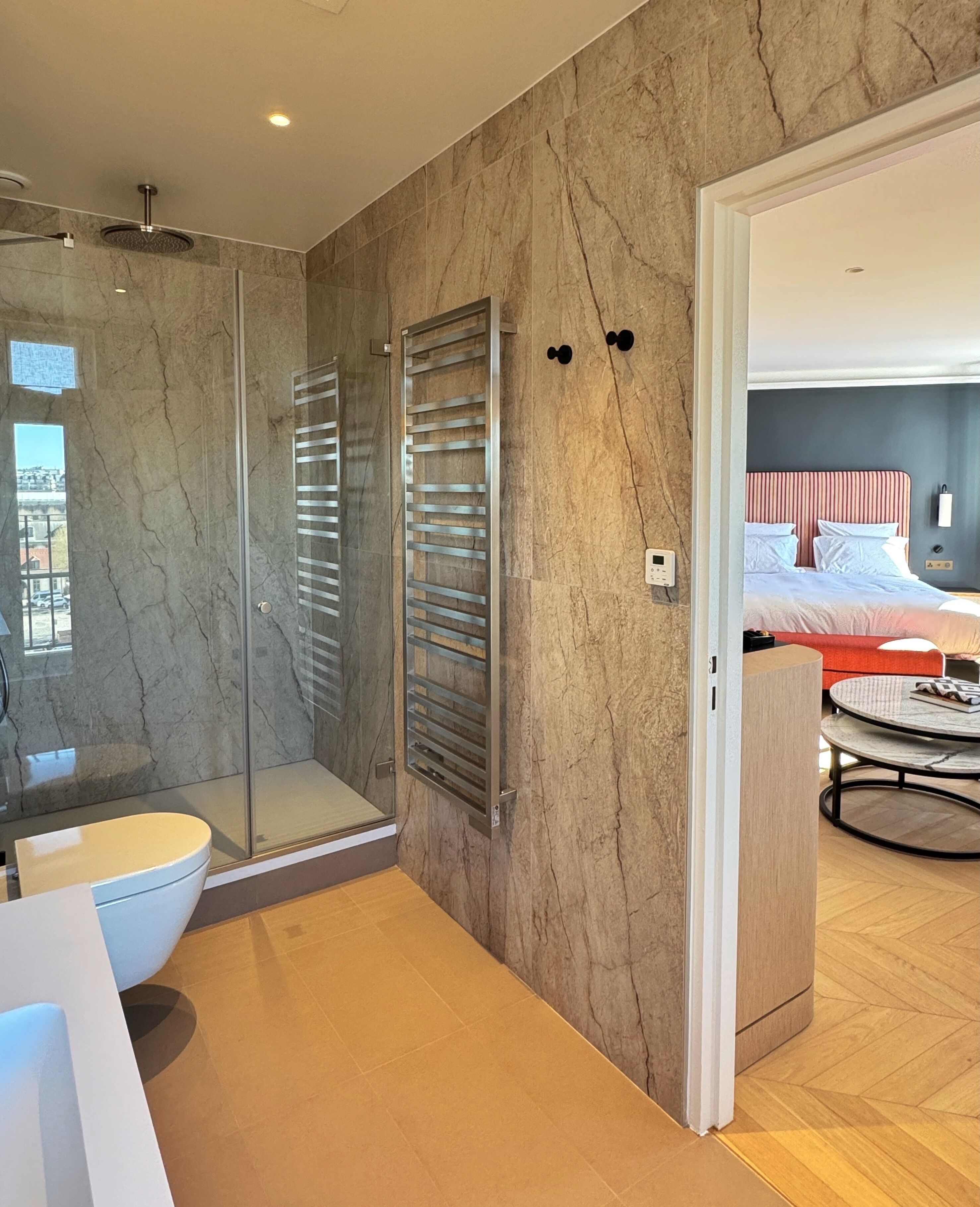 A modern bathroom with a glass shower enclosure, a toilet, and a sink.