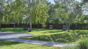 Een verzorgd park met een grindpad, bankjes en een kleine kiosk.