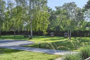 A well-maintained park with a gravel path, benches, and a small gazebo.
