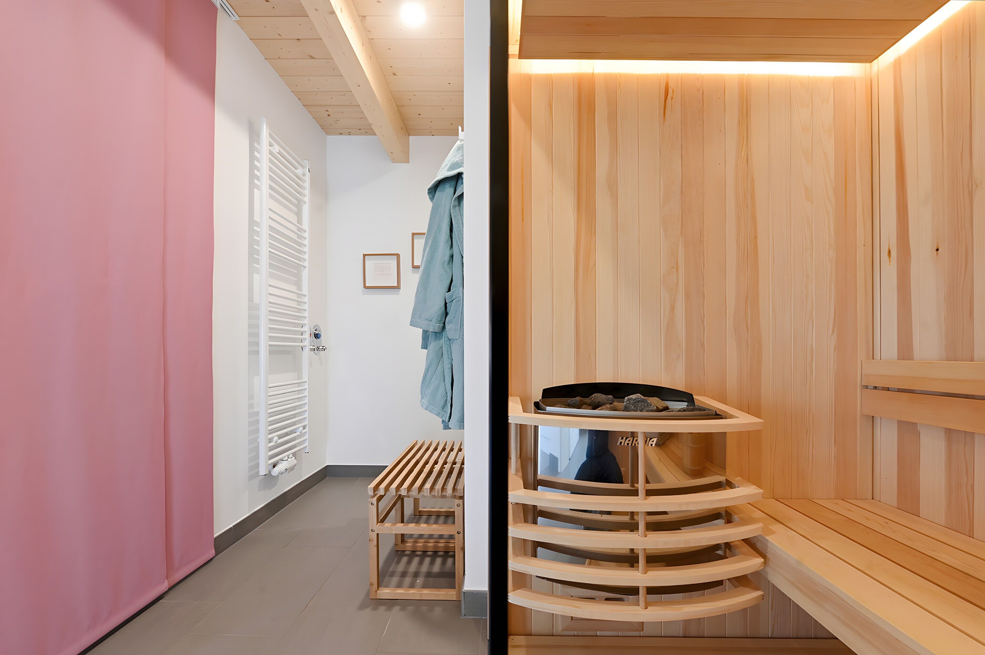 A wooden sauna with a bench, a wooden shelf with stones, and a bench with a towel.