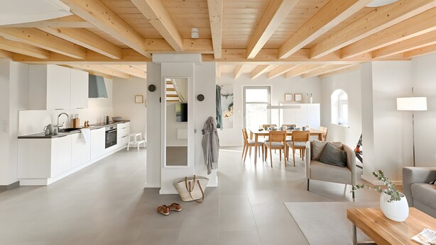 A spacious living area with a kitchen, dining table, and seating.