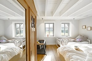A room with two beds, a window, and a small table.
