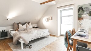 Una camera da letto con un letto, comodini e un'area pranzo con tavolo e sedie.