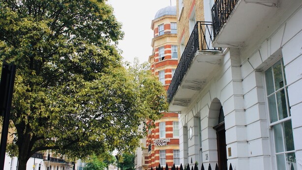 A street view with a building labeled "HELCOMBE COURT" and a tree-lined sidewalk. - Victorian appartement in Marylebone (London)