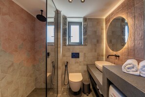 A modern bathroom with a glass shower enclosure, a toilet, a sink, and a vanity with a mirror. - Villa Dimitrios - With Private Pool (Rethymno)