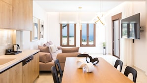 A modern kitchen with a wooden countertop, a dining table, and a sofa. - Villa Santa Irini 3 - With Heated Pool (Rethymno)