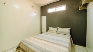 A small, simple bedroom with a bed, a window, and a door. - Flat Para 2 Pessoas a Poucos Metros do Aeroporto (Fortaleza)