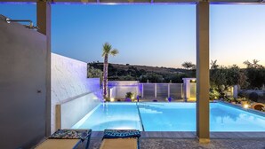 A modern outdoor swimming pool with a clear view of the surrounding landscape and a well-lit patio area. - Villa Me - With Private Pool (Mylopotamos)