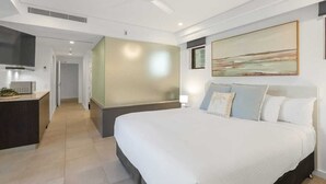 Une chambre d’hôtel moderne avec un grand lit, un bureau et un tableau au mur.