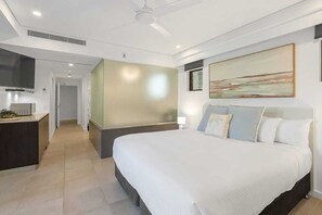 Ein modernes Hotelzimmer mit einem großen Bett, einem Schreibtisch und einem Gemälde an der Wand.
