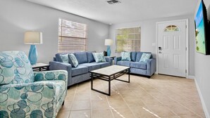A living room with two sofas, a coffee table, and a lamp.