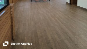 A spacious room with wooden floors, large windows, and a ping pong table.