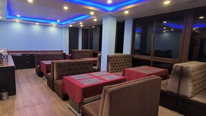 A restaurant with booths and tables, blue walls, and large windows.