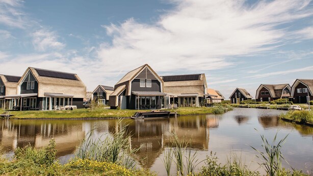 Une rangée de maisons modernes, avec un canal au premier plan.