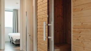 Une chambre d’hôtel avec un mur en bois, un lit et une porte coulissante.