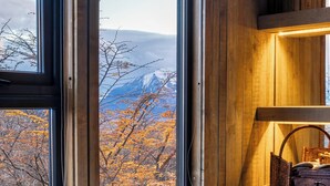Kylpyhuone, jossa on suuri ikkuna, puuseinät ja valkoinen kylpyamme.