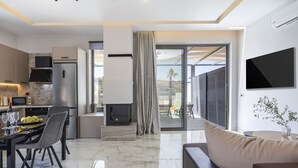 Una cucina moderna con zona pranzo, un soggiorno con divano e un'ampia finestra con vista sull'esterno.