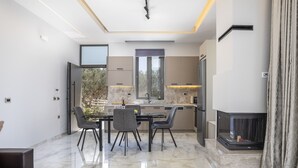 Una cucina moderna con zona pranzo, camino e un'ampia finestra.
