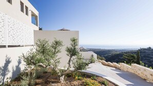 A modern building with a white facade, a balcony with olive trees, and a view of a hilly landscape. - Santa Irini Villas - With 3 Heated Pools (Rethymno)