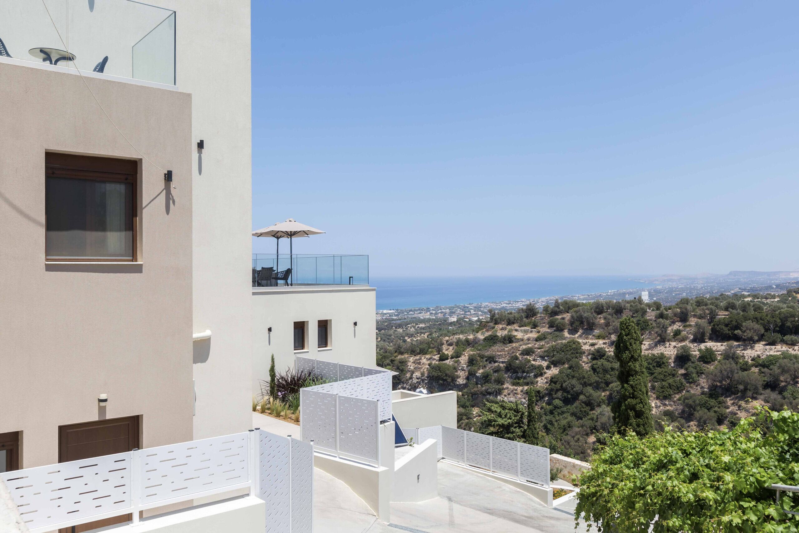Ein modernes Gebäude mit einem Balkon mit Blick auf eine Küstenlandschaft.