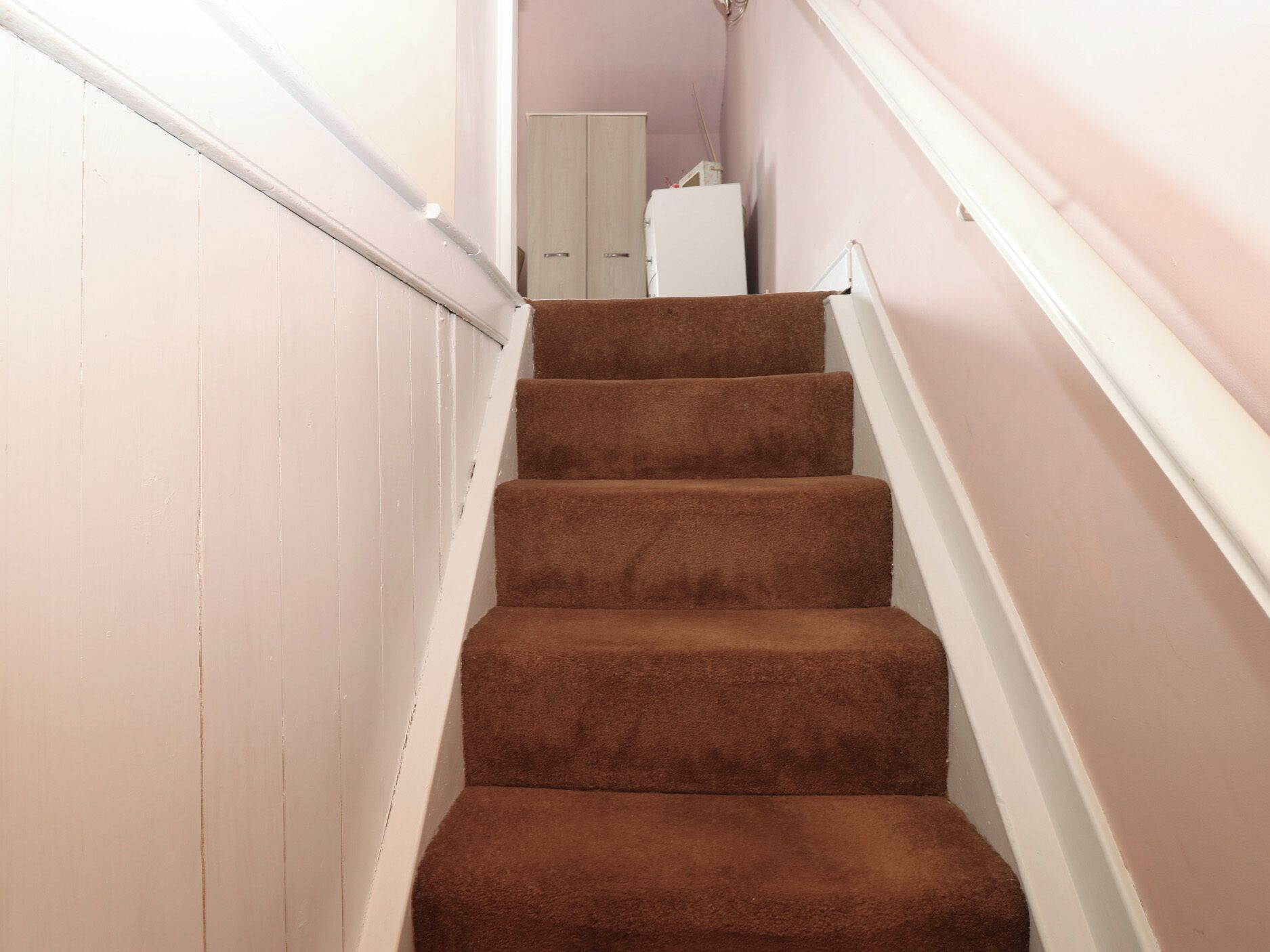 Eine Treppe mit Teppichstufen, die zu einer Zwischenebene führt.